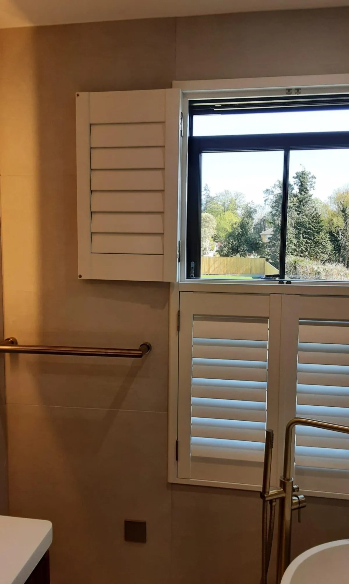 Tier-on-tier plantation shutters with upper louvres open in a bathroom