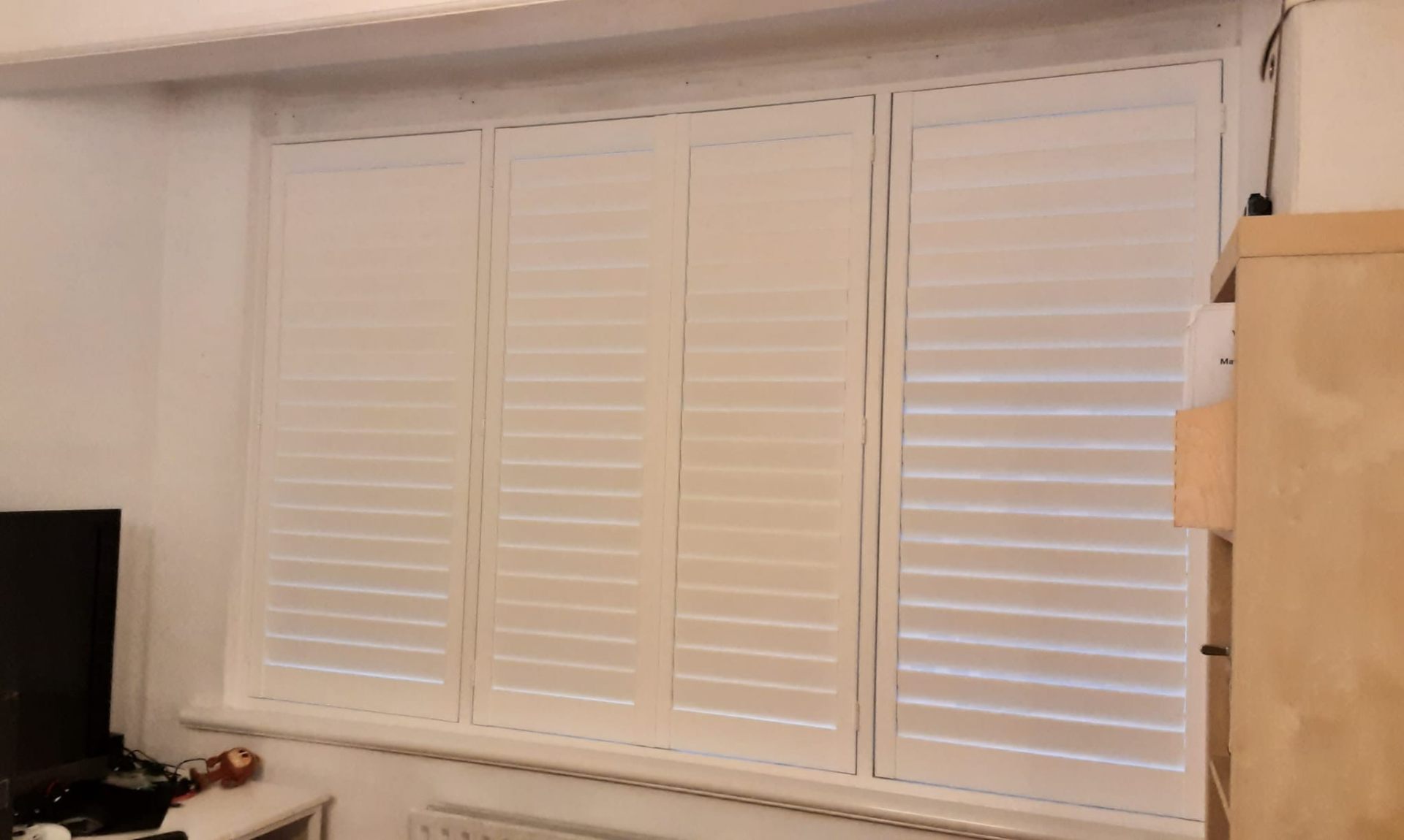 Four-panel plantation shutters fully closed for complete privacy