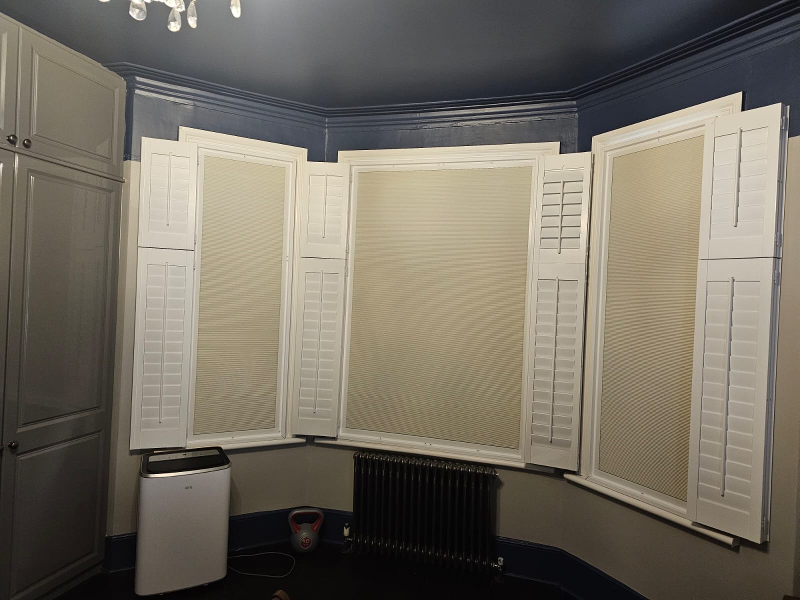 Plantation shutters fitted in a kitchen between wall cabinets