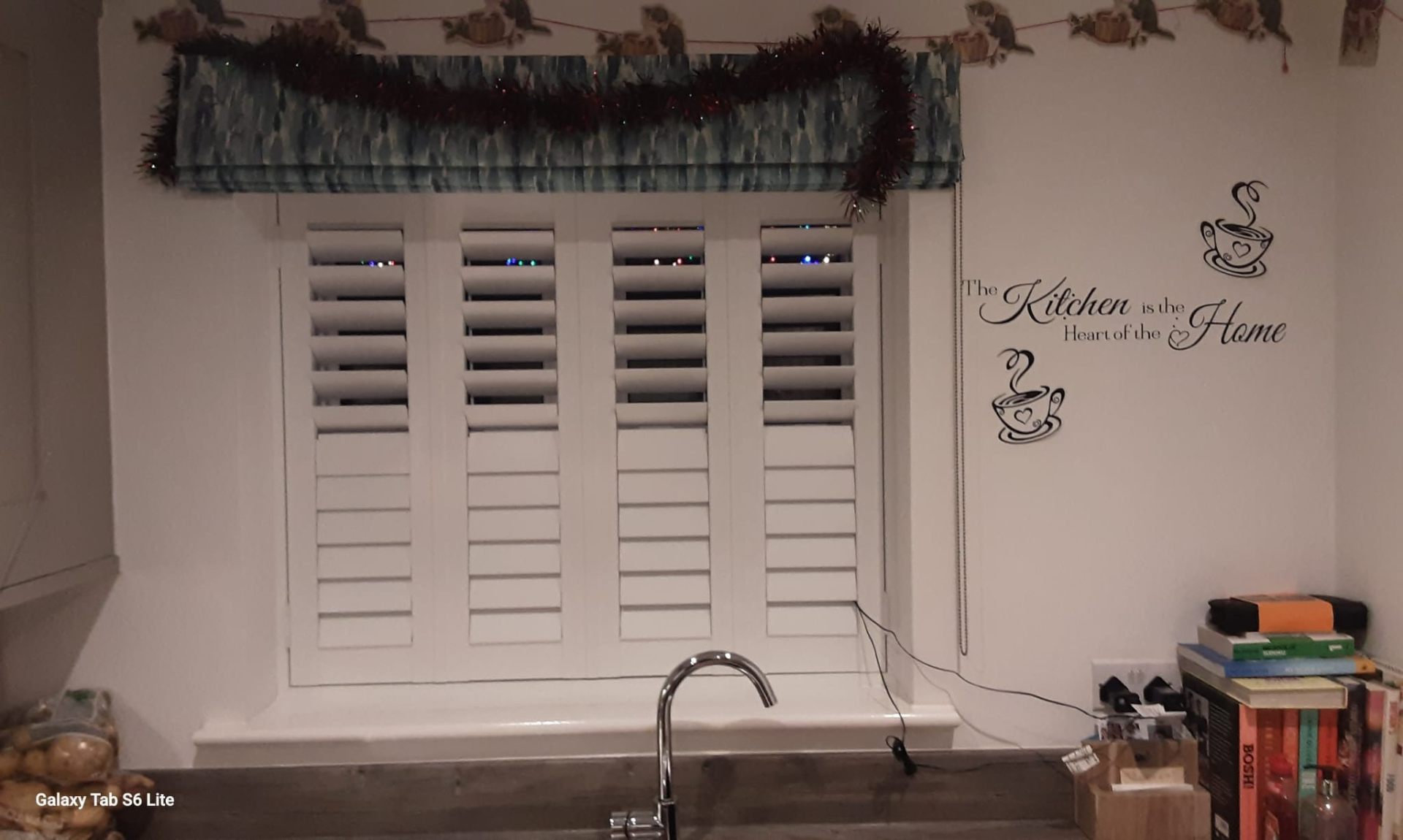 Kitchen plantation shutters with decorative roman blind pelmet above