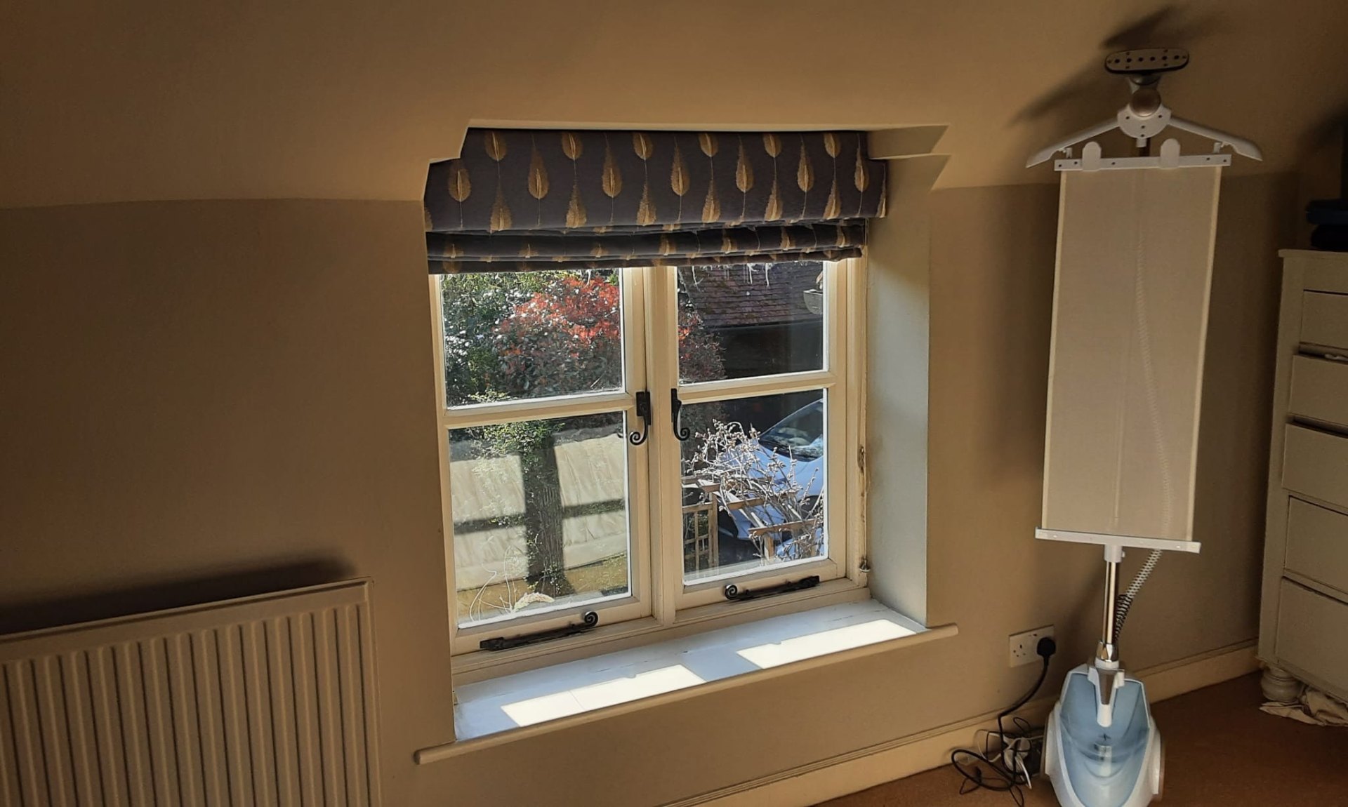 Roman blind with leaf pattern fitted on a period casement window